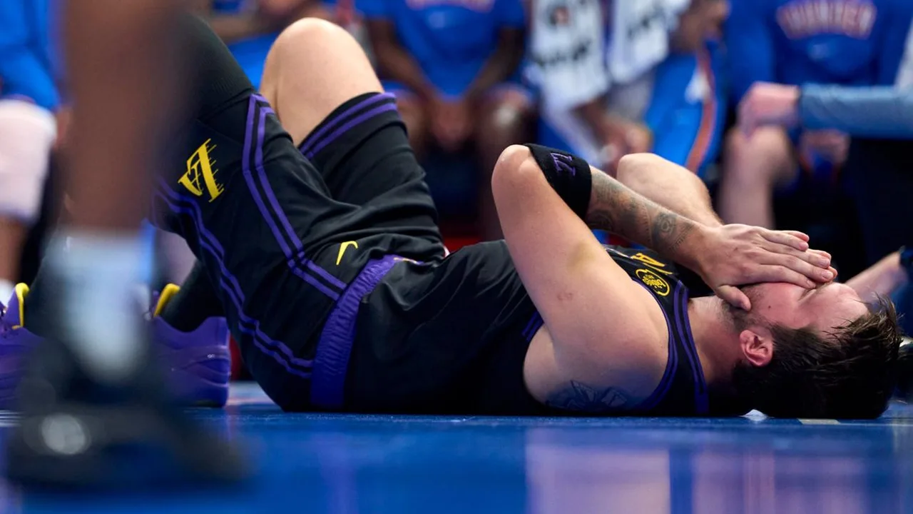 Luka Doncic dos Lakers segurando coxa esquerda durante partida, evidenciando lesão muscular que o afastará da temporada