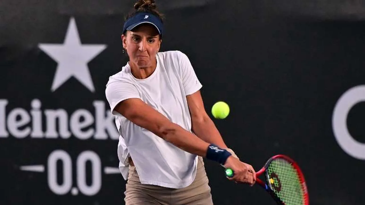 Ingrid Martins saca durante partida de duplas em torneio WTA na quadra de saibro vermelha