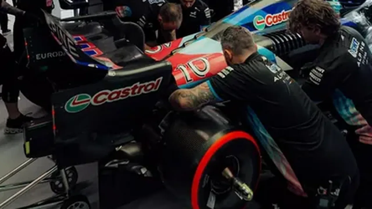 Mecânicos trabalhando em motor de F1 no paddock com ferramentas técnicas especializadas