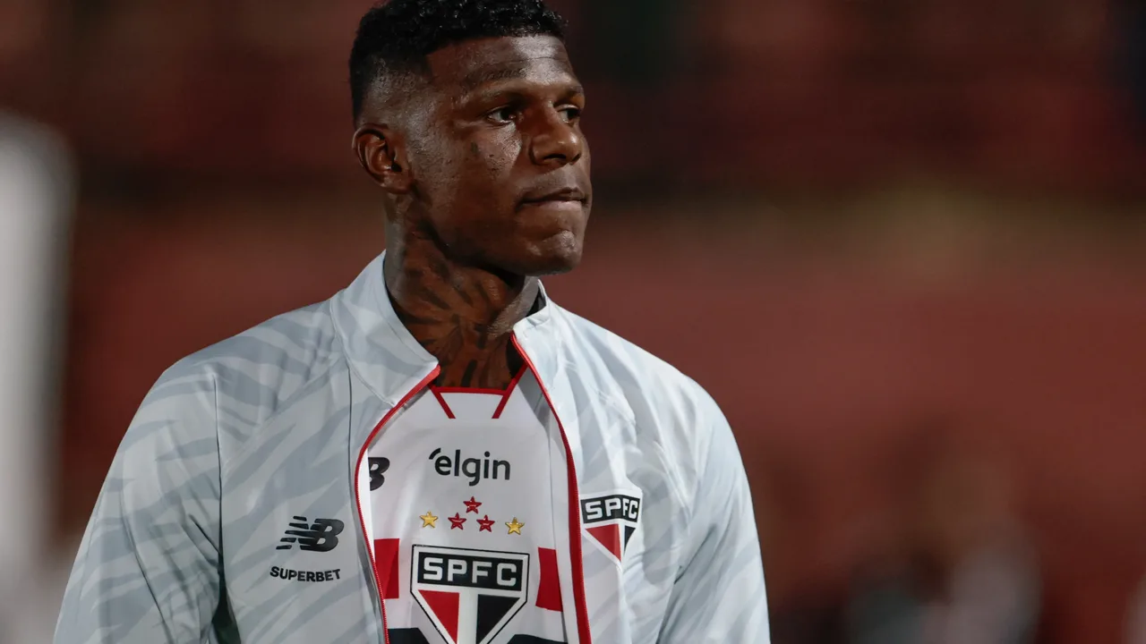 Zagueiro do São Paulo em ação defensiva durante partida no Morumbi com torcida ao fundo