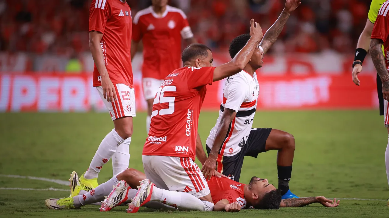 Jogador do Internacional sendo atendido pelo departamento médico após choque de cabeça em campo