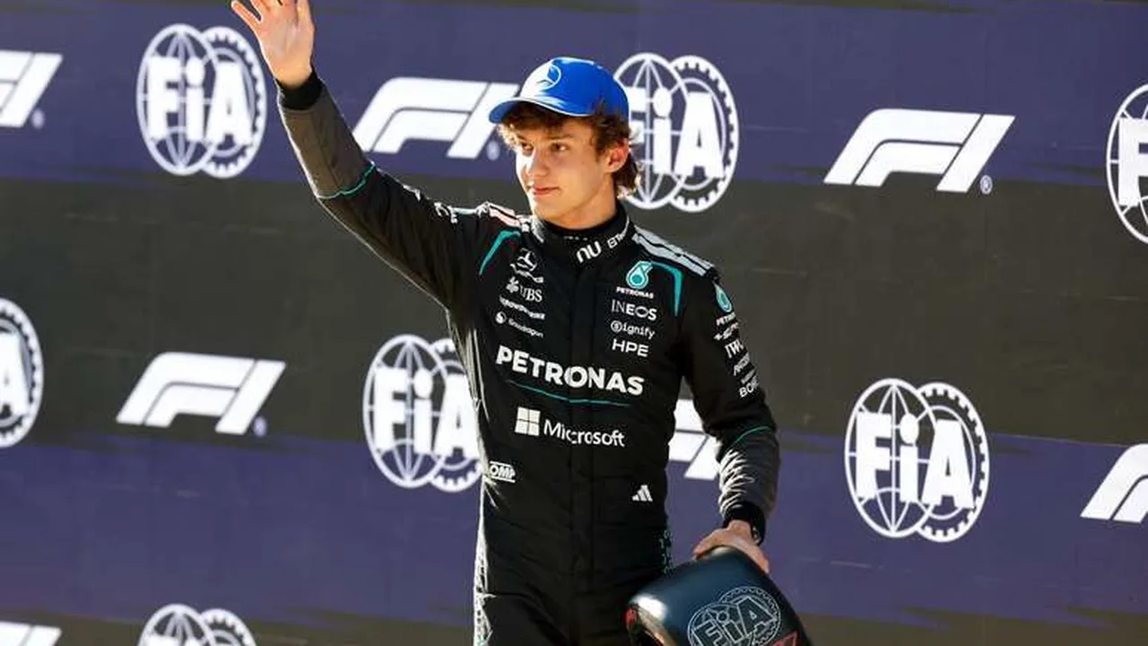 Kimi Antonelli celebra vitória no pódio do GP Japão enquanto bandeiras da Mercedes tremulam ao fundo em Suzuka