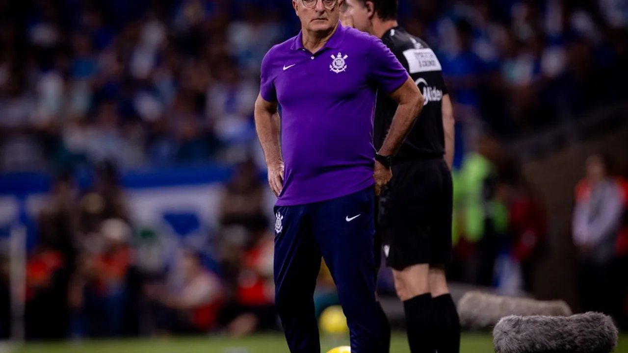 Técnico comandando time de futebol em campo durante partida do Brasileirão com torcida ao fundo