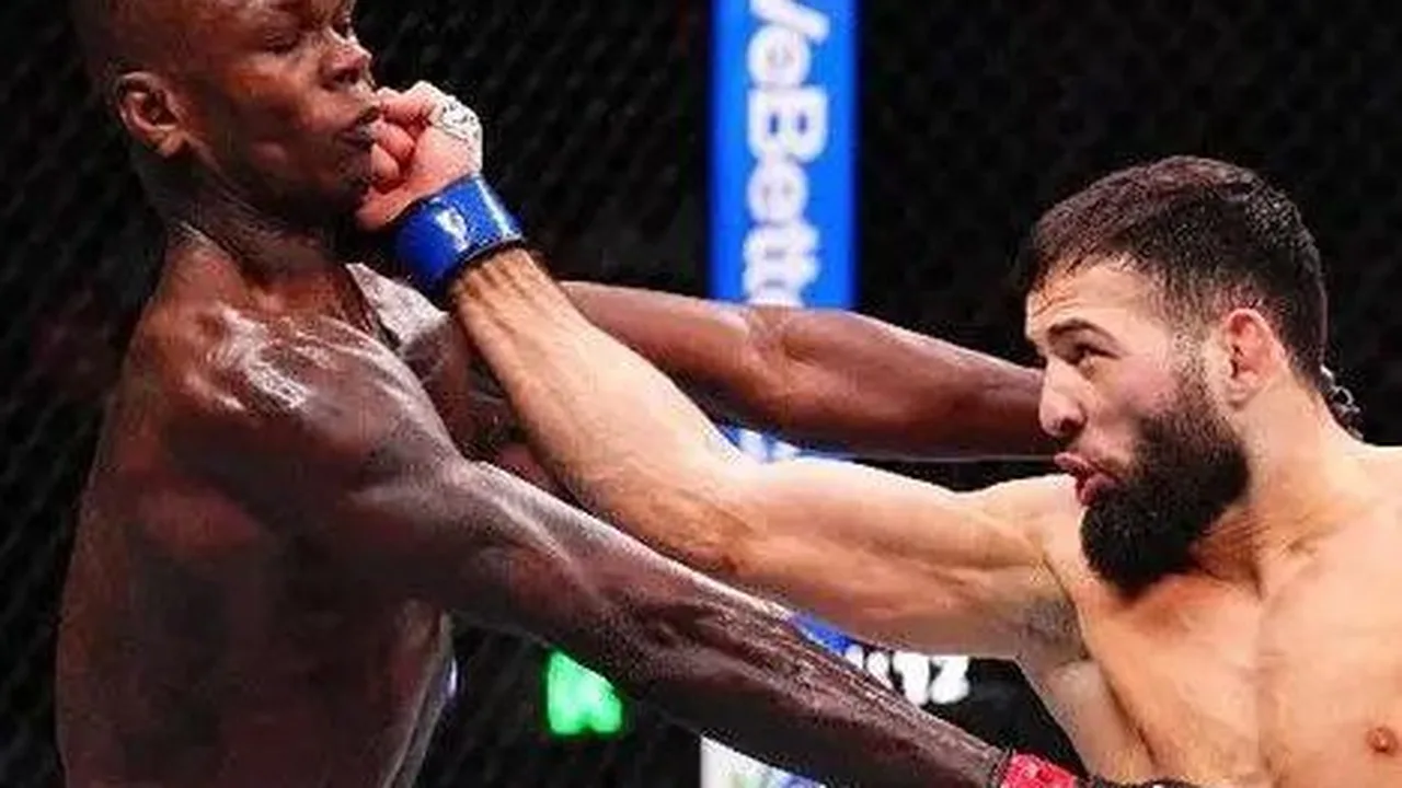 Israel Adesanya cabisbaixo após derrota no octógono do UFC Seattle com expressão de frustração