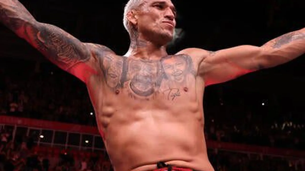 Lutadores brasileiros do UFC posando com cinturões em octógono durante evento principal da International Fight Week