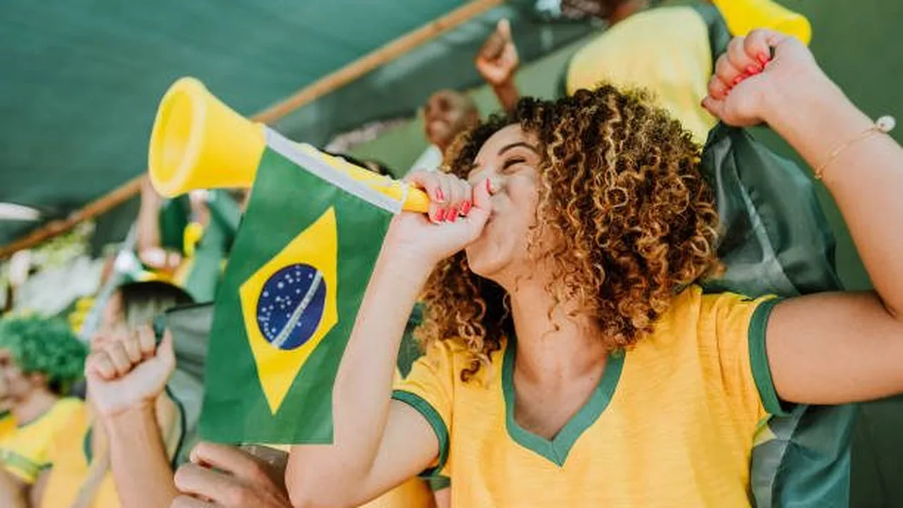 Gandula segurando papel durante partida de futebol em estádio lotado