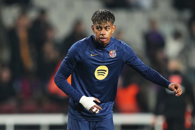 Yamal driblando durante partida do Barcelona na Champions League aos 18 anos