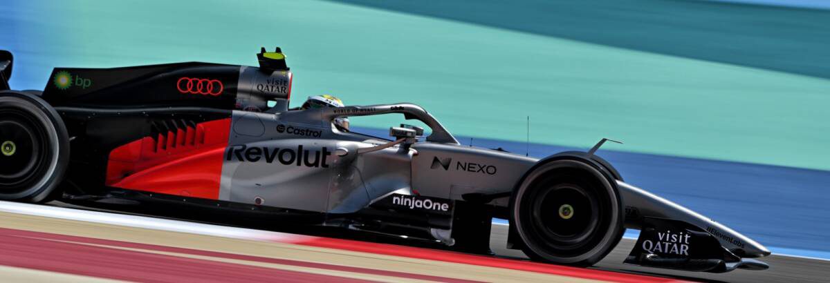 Carro da Audi F1 nos boxes durante pit stop com mecânicos trabalhando no motor