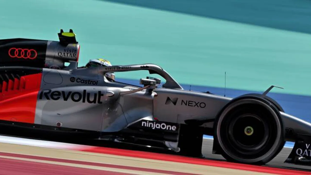 Carro da Audi F1 nos boxes durante pit stop com mecânicos trabalhando no motor
