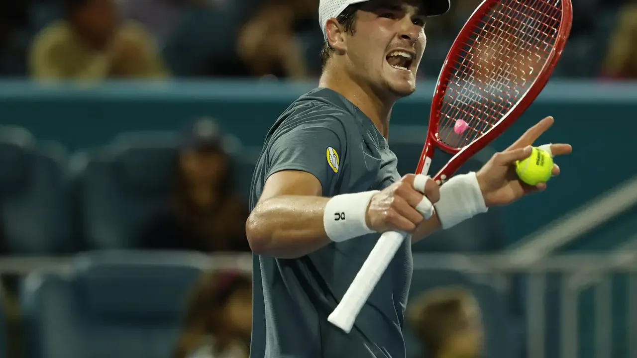 João Fonseca comemorando vitória em quadra de saibro com raquete erguida em Monte Carlo