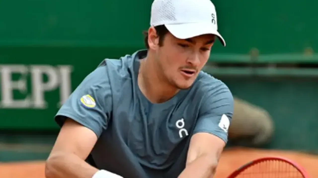 João Fonseca em ação na quadra de saibro durante Masters 1000, empunhando raquete com expressão concentrada