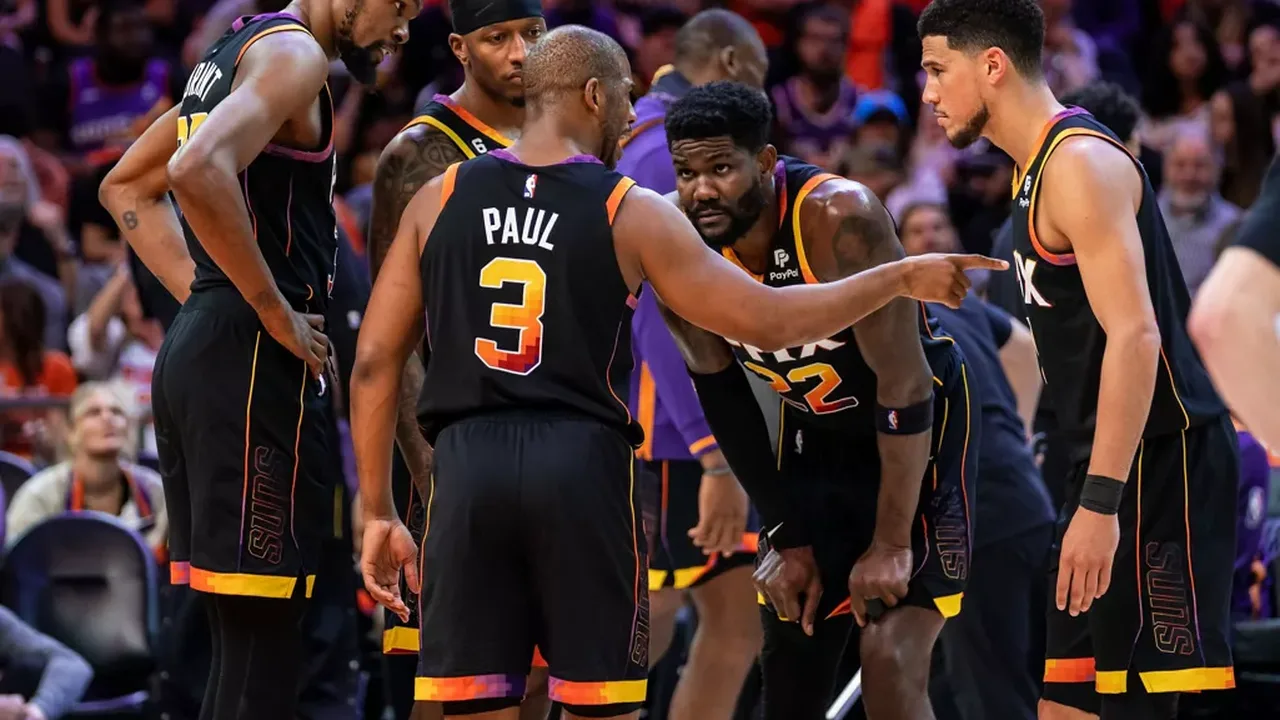 Devin Booker do Phoenix Suns encara Nikola Jokic do Denver Nuggets durante partida dos playoffs da NBA