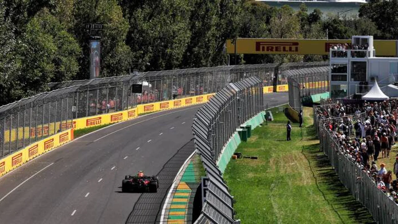 Paddock da Fórmula 1 com caminhões de equipes e containers sendo organizados para transporte intercontinental