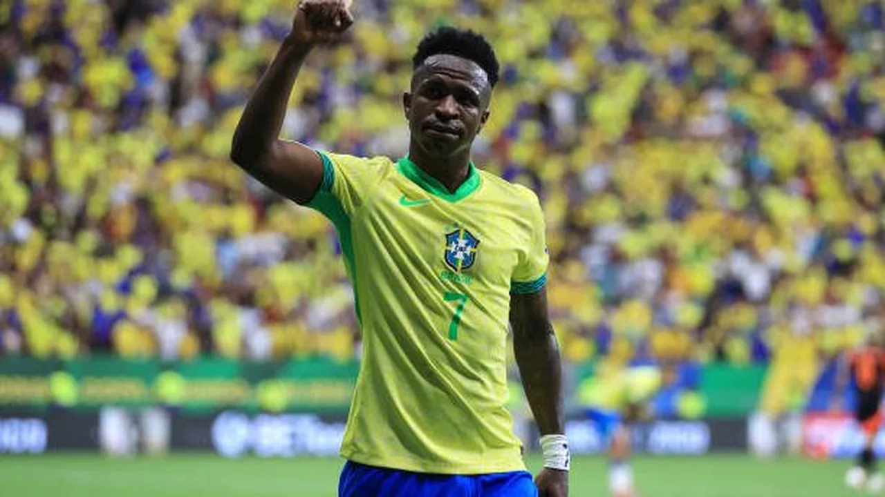 Jovens jogadores brasileiros comemorando em campo durante partida de competição europeia com bandeiras do Brasil ao fundo