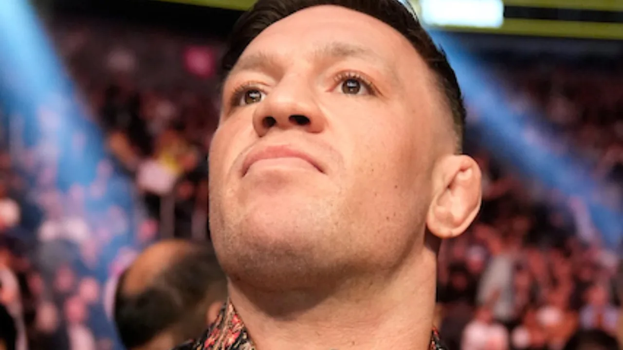 Conor McGregor no octógono do UFC durante luta, com expressão focada e postura de combate