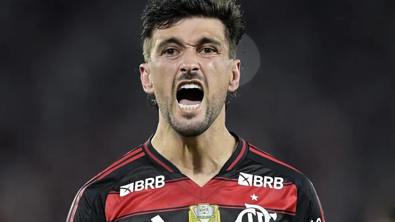 Arrascaeta comemorando gol pelo Flamengo enquanto Abel Ferreira gesticula à beira do campo pelo Palmeiras