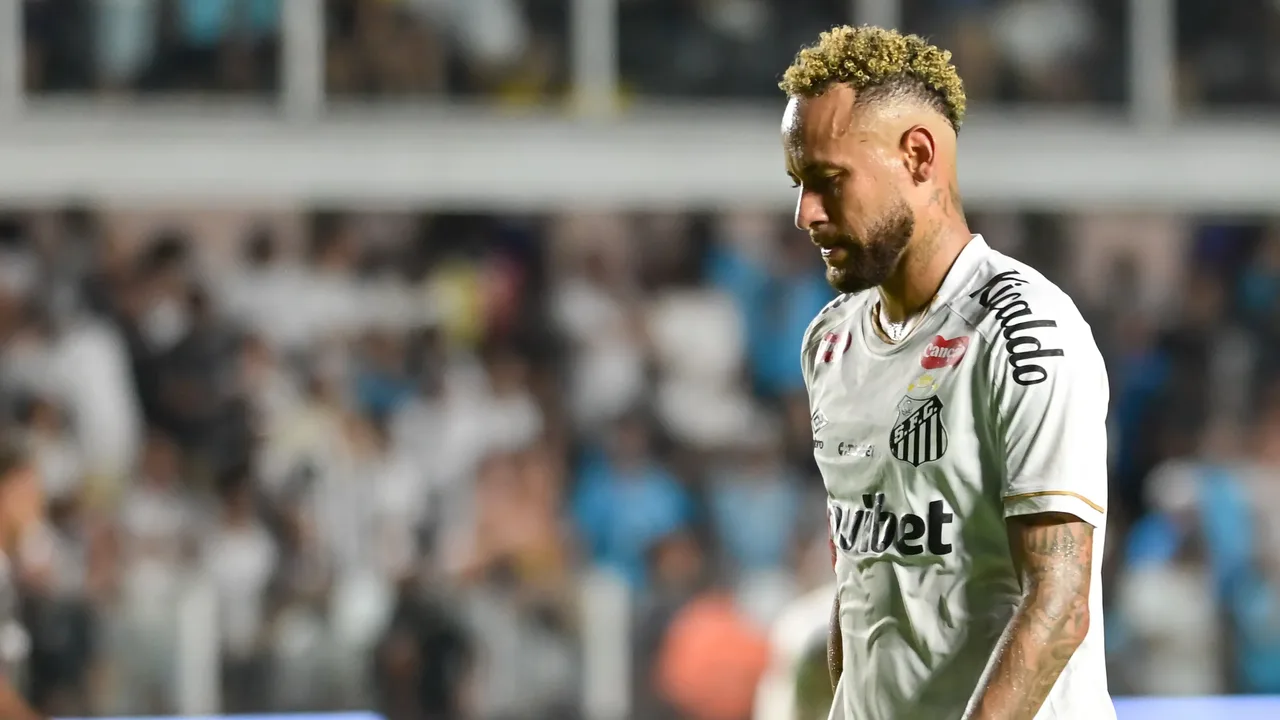Neymar com camisa do Santos em campo durante partida noturna, torcida ao fundo