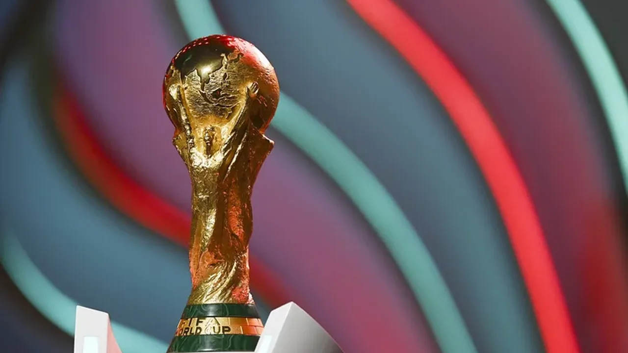 Troféu da Copa do Mundo FIFA sobre fundo dourado com bandeiras de seleções participantes