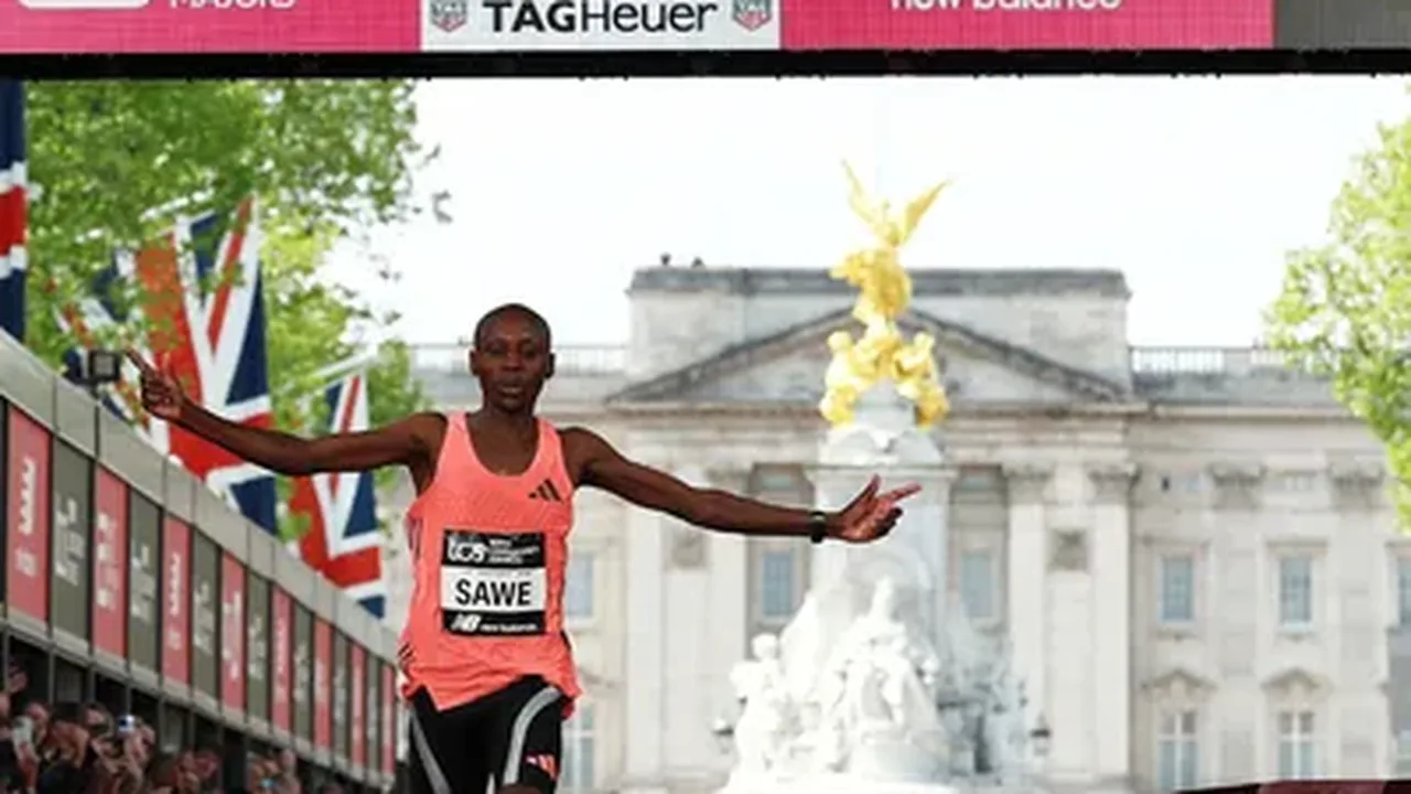 Sebastian Sawe e Yomif Kejelcha cruzando a linha de chegada da Maratona de Londres com multidão ao fundo