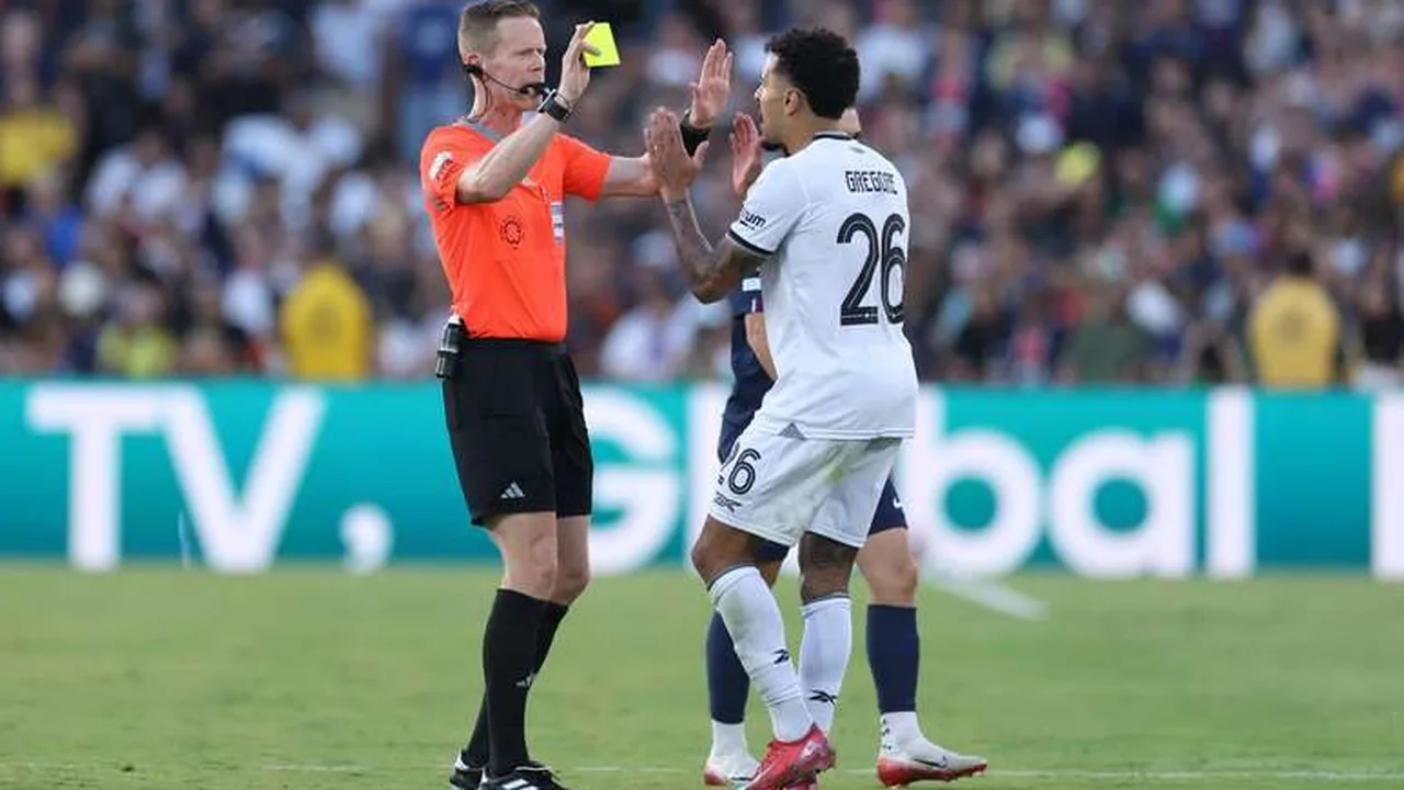 Árbitro mostrando cartão amarelo durante partida da Copa do Mundo com jogadores ao redor