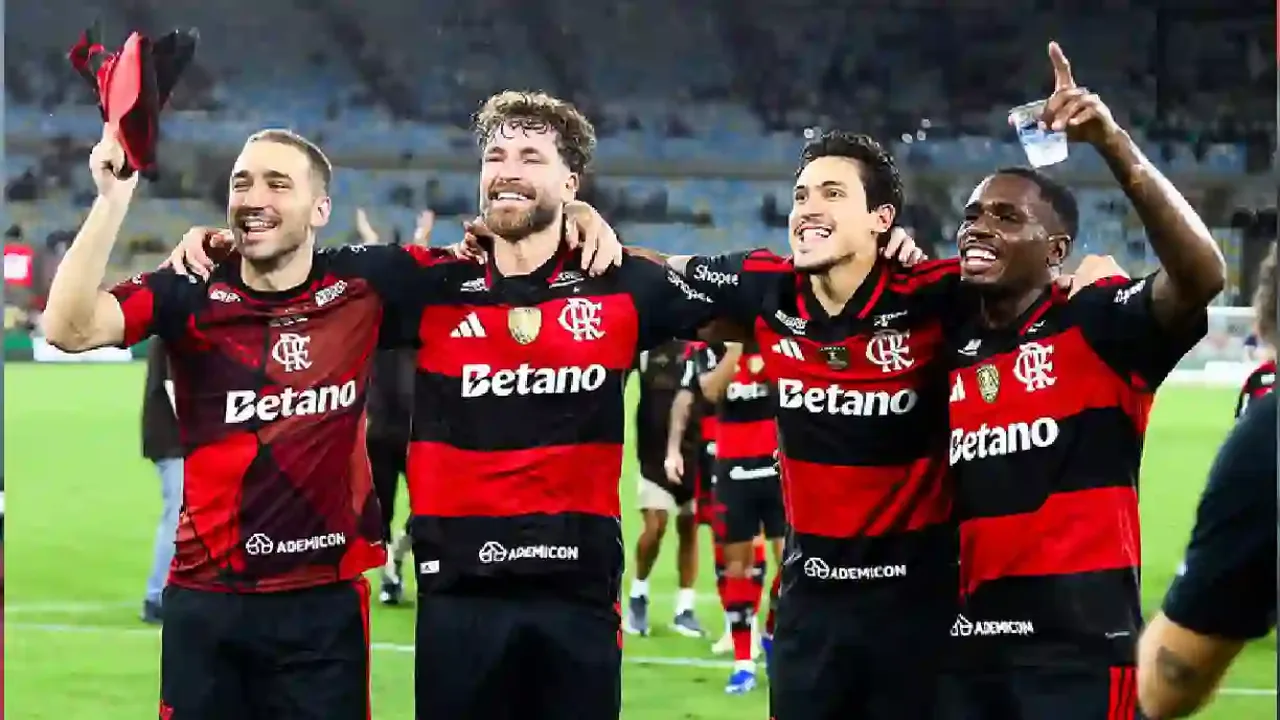 Jogadores do Flamengo em campo durante partida da Copa Libertadores, com torcida ao fundo