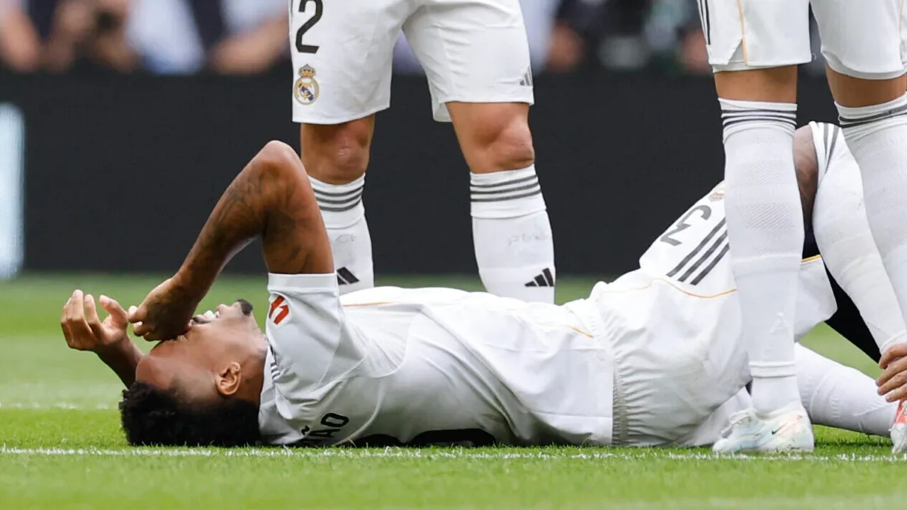 Éder Militão de joelhos no gramado segurando a perna esquerda após sofrer lesão muscular grave
