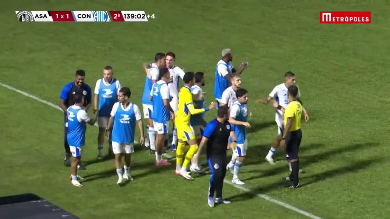 Estádio de futebol com placa de casa de apostas e jogadores em campo durante partida do Campeonato Sergipano