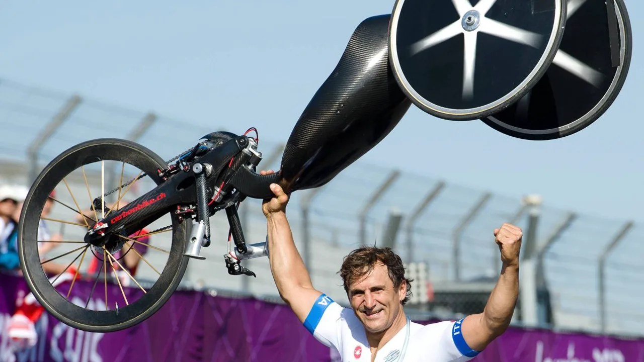 Alex Zanardi em competição de paraciclismo com handbike, usando capacete e uniforme da seleção italiana