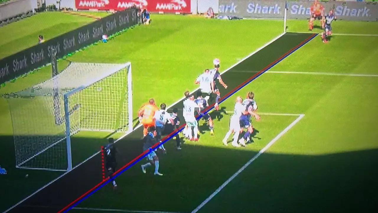 Árbitro revisando lance no monitor do VAR à beira do campo durante partida de futebol