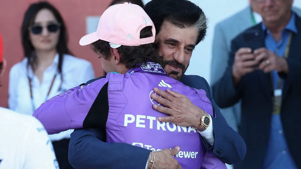 Motor V8 de F1 em destaque no paddock, com mecânicos ao redor e fumaça saindo do escapamento