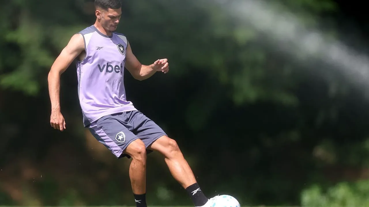Zagueiro do Botafogo em treino no campo, com o escudo alvinegro ao fundo, representando crise defensiva no Brasileirão 2026