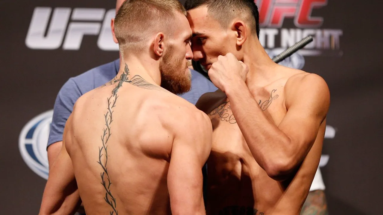Conor McGregor e Max Holloway frente a frente no peso-pena do UFC, octógono ao fundo