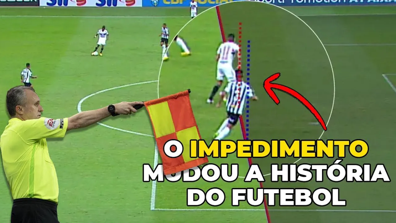 Árbitro levantando a bandeira de impedimento em partida de futebol, com jogadores em campo ao fundo