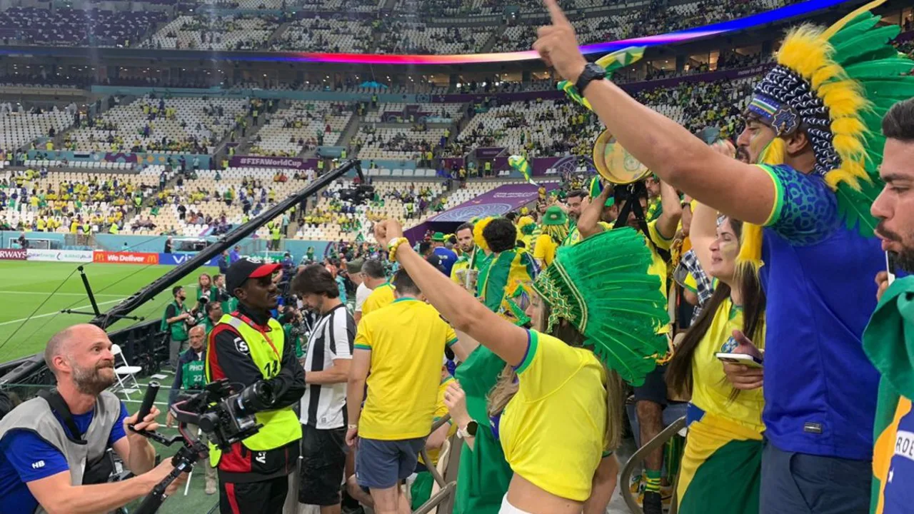 Jogadores da seleção iraniana em campo durante partida oficial, com bandeira do Irã ao fundo