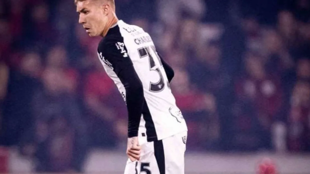 Estádio Neo Química Arena visto de fora com bandeiras do Corinthians e céu nublado ao fundo