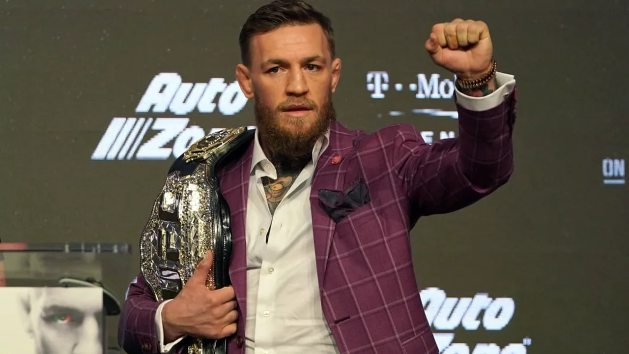 Conor McGregor em posição de guarda no octógono do UFC, com expressão concentrada antes de luta