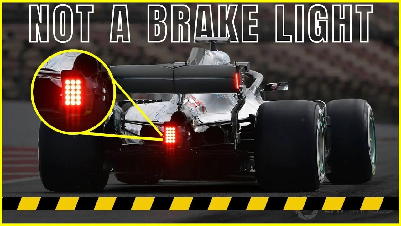 Carro de Fórmula 1 com luz traseira acesa sob chuva intensa no Circuito Gilles Villeneuve
