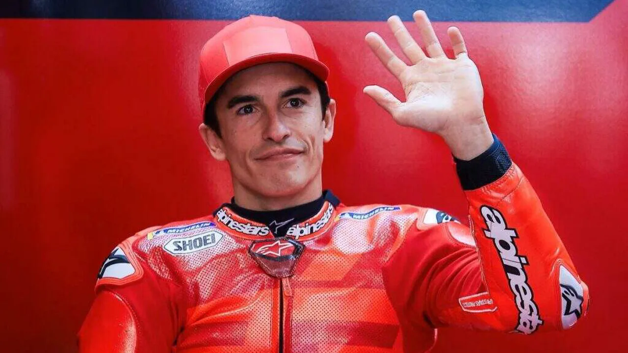 Marc Márquez com macacão da Ducati no paddock da MotoGP, capacete na mão, ao lado da moto vermelha