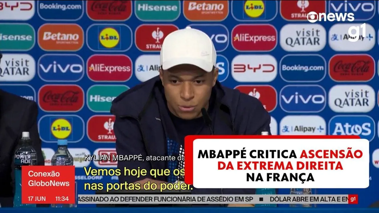 Kylian Mbappé em coletiva de imprensa durante a Eurocopa 2024, com expressão séria ao responder sobre política na França
