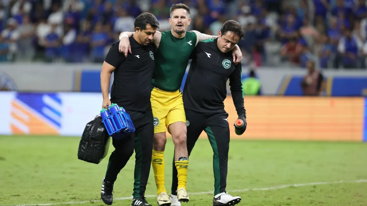Goleiro Tadeu sendo amparado no gramado do Mineirão após lesão no tornozelo contra o Cruzeiro