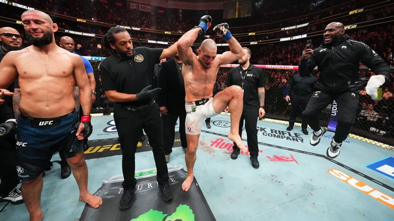 Khamzat Chimaev colocando o cinturão dos pesos-médios em Sean Strickland após o UFC 328 em Newark
