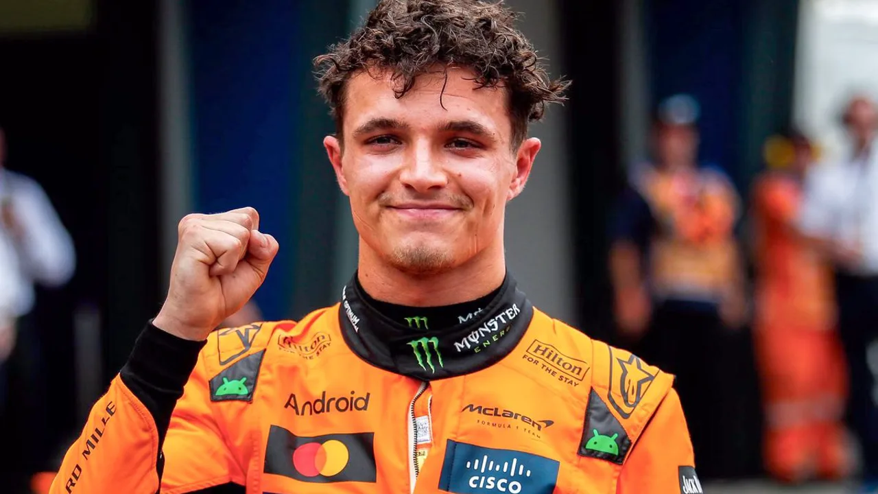 Lando Norris com capacete McLaren no paddock da Fórmula 1, olhando para equipe técnica