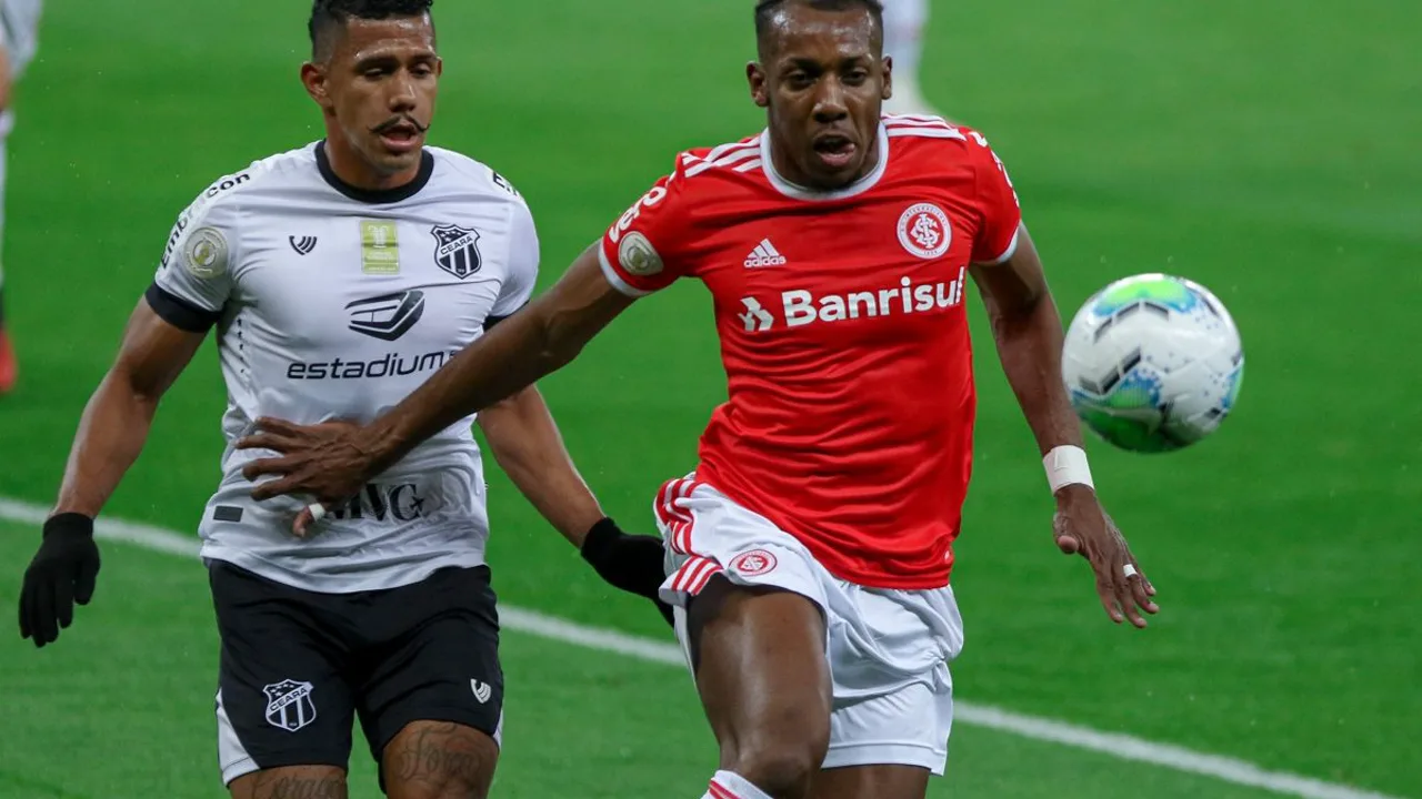 Vinicius Jr. com expressão determinada em campo, uniforme do Real Madrid, sob holofotes do Santiago Bernabéu