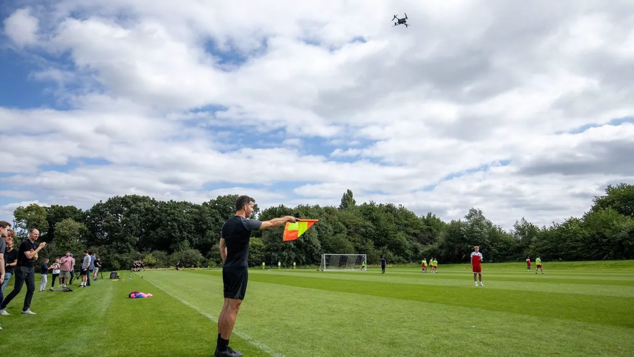 Drone sobrevolando campo de futebol ao entardecer durante sessão de treino fechada na Championship inglesa