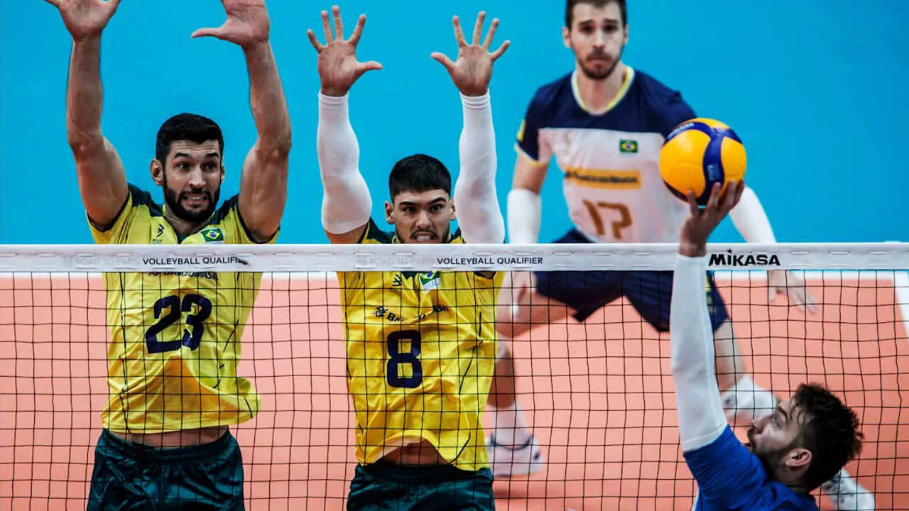 Líbero com colete de cor diferente realizando defesa no piso durante partida de vôlei de quadra