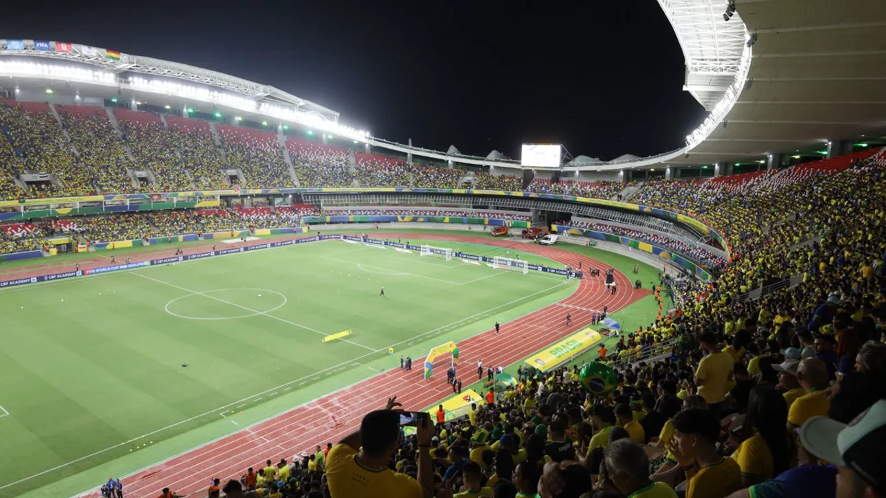 Bandeira da Arábia Saudita ao lado do troféu da Copa do Mundo FIFA em estádio iluminado