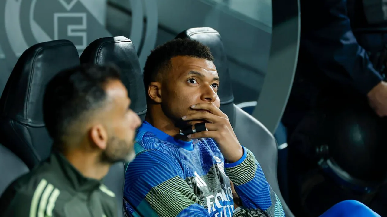 Kylian Mbappé no banco de reservas do Real Madrid no Santiago Bernabéu com arquibancadas vazias ao fundo