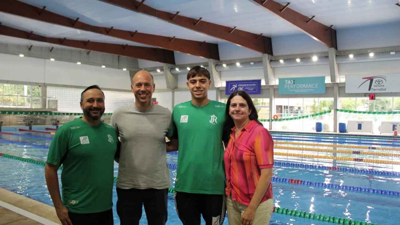Jovem nadador brasileiro em piscina semiolímpica durante treino matinal, óculos de natação na testa