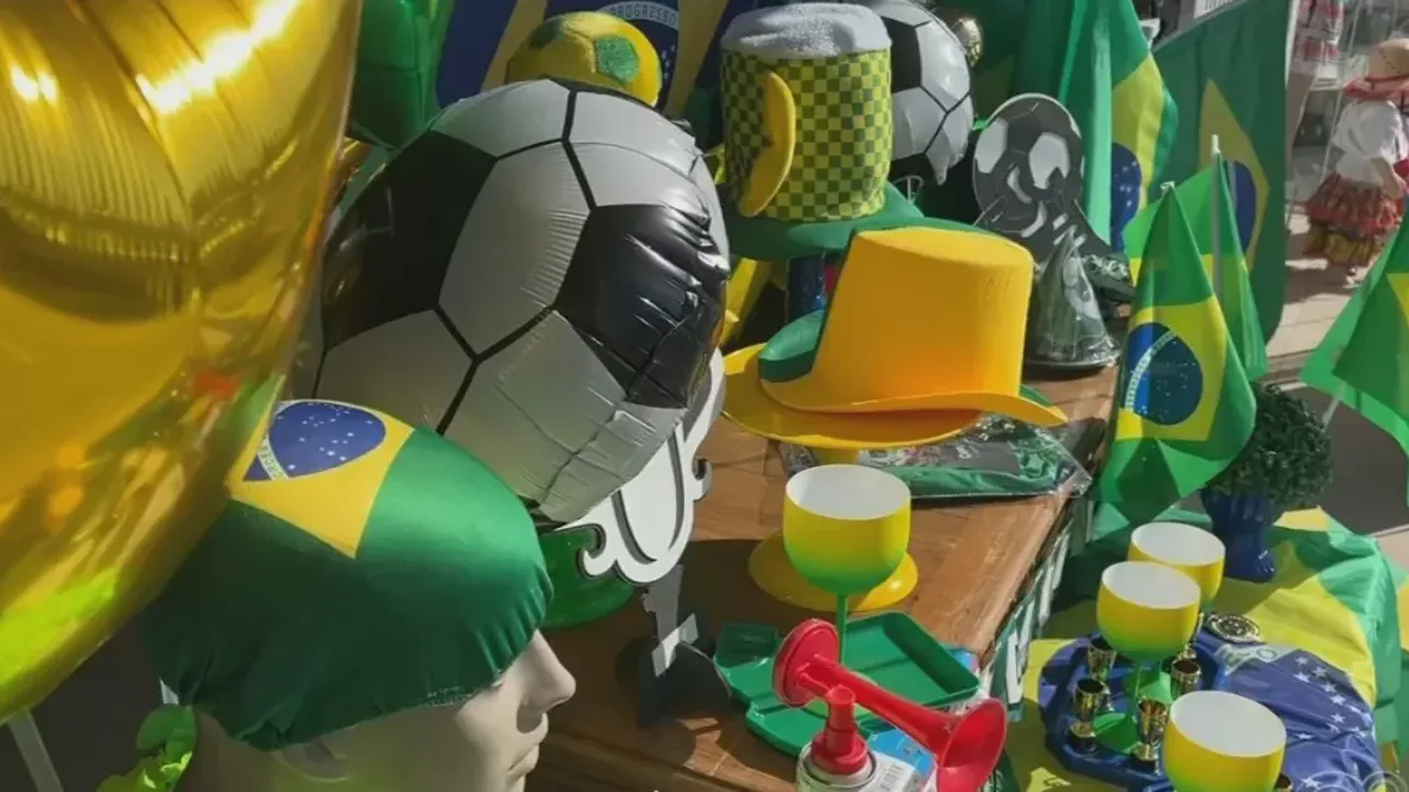 Vitrine de loja em Botucatu com camisetas da Seleção Brasileira ao lado de artigos de festa junina