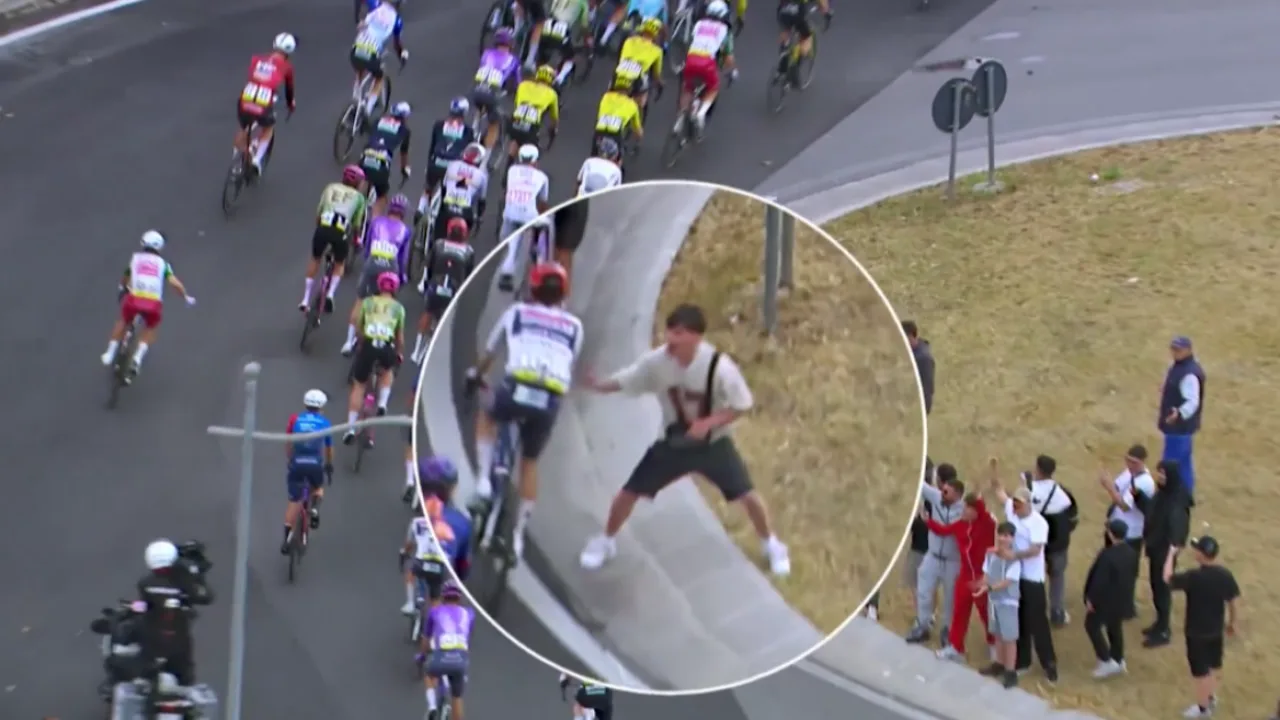 Pelotão de ciclistas passando por rotatória urbana em Nápoles durante etapa do Giro d'Italia 2026
